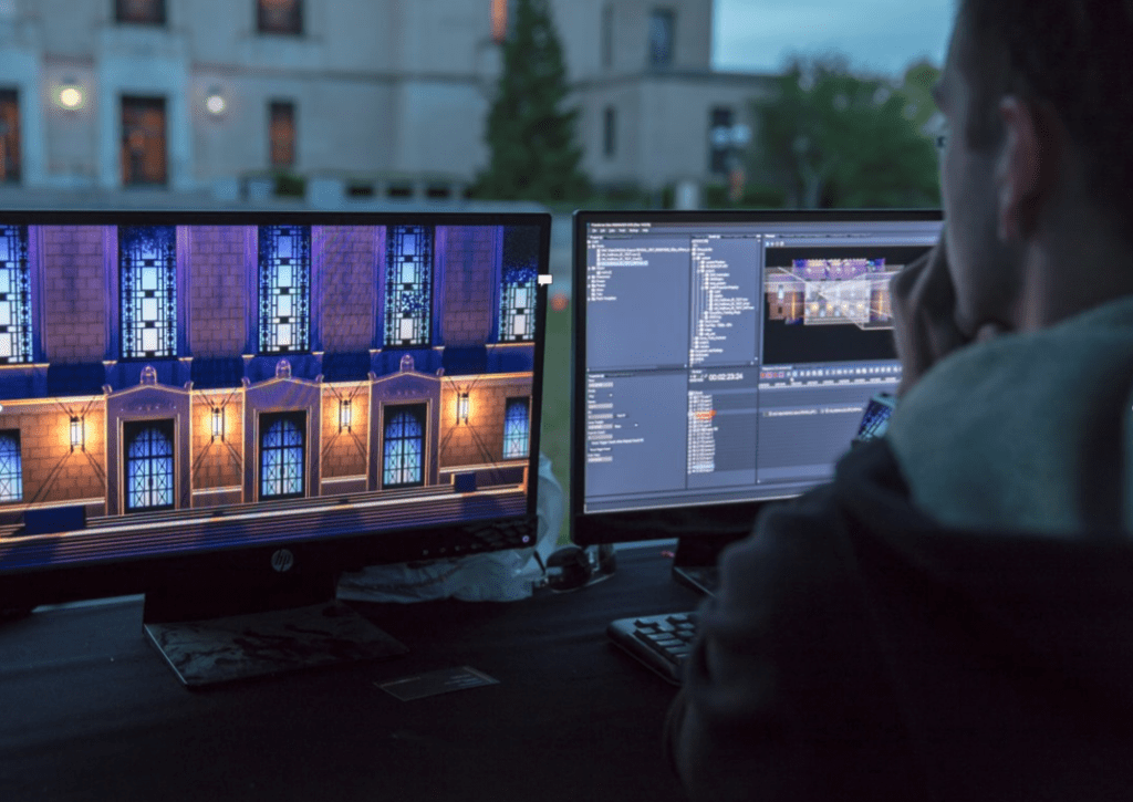 A virtual event planner looks at their computer screens while the event is starting.