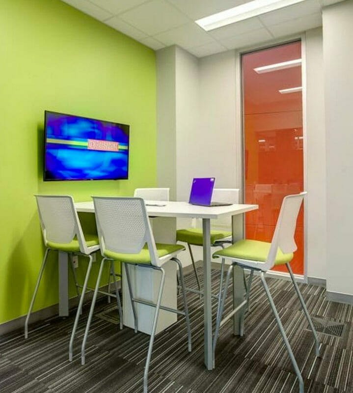 Small huddle space with a TV and 5 chairs.